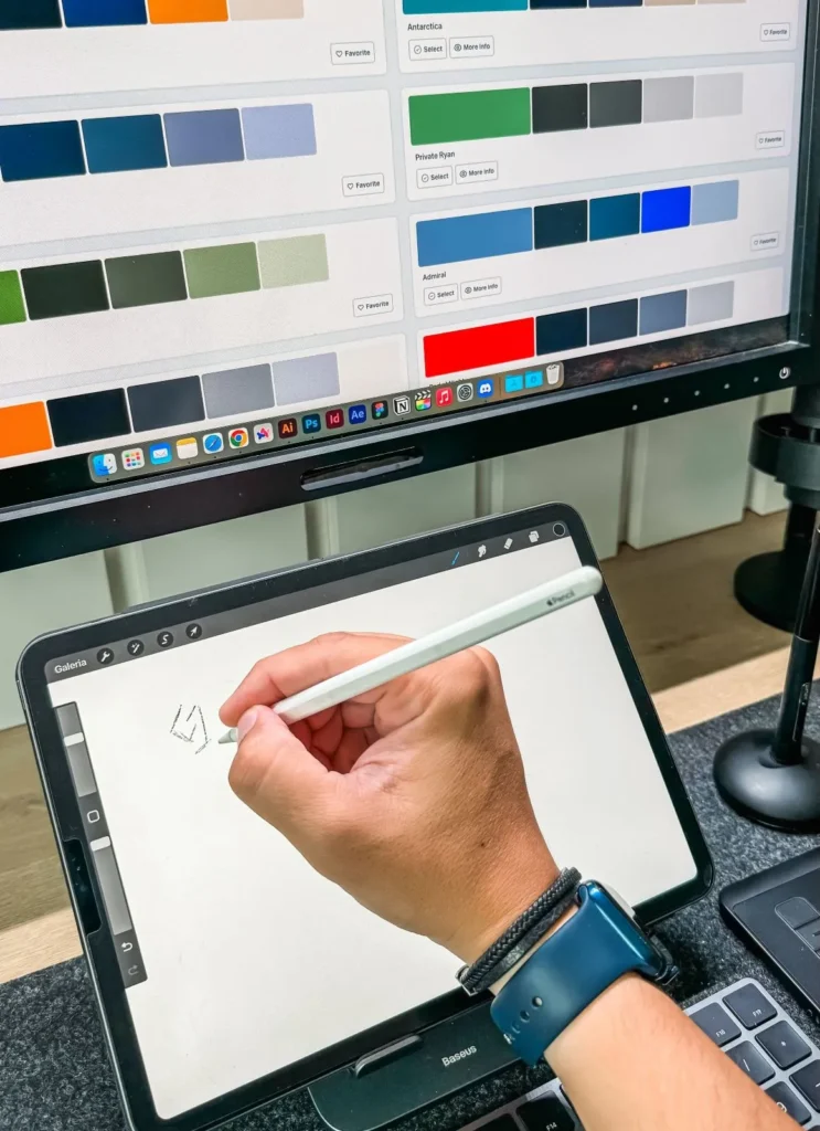 pessoa desenhando em um tablet e ao fundo paleta de cores