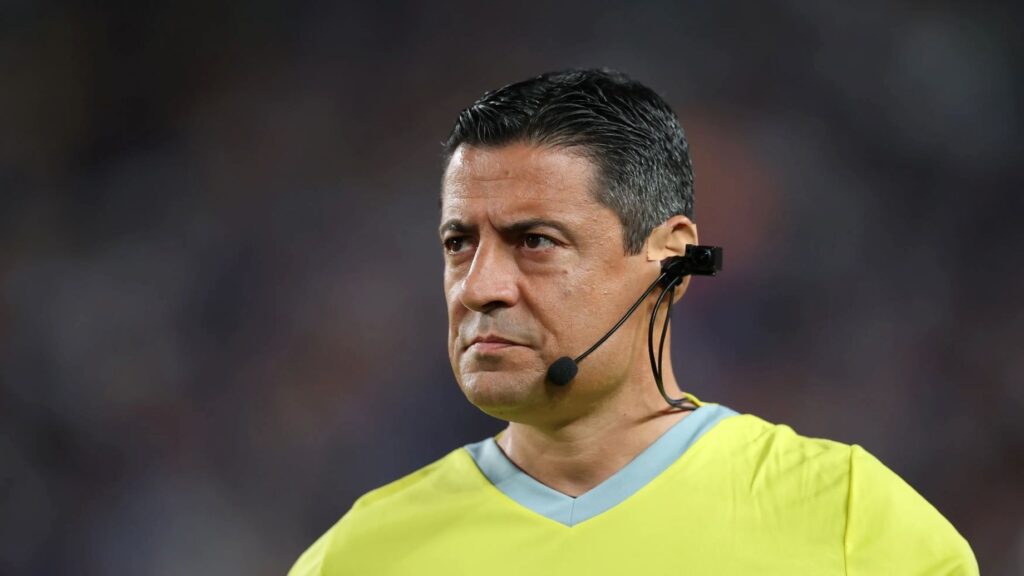 Imagem de um arbitro de futebol da copa do mundo utilizando um microfone ligado a uma micro câmera a visão do arbitro 