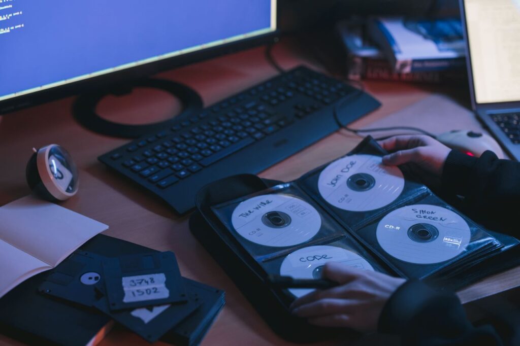 pessoa em frente ao um computador com um album ou bolsas de cds de jogos